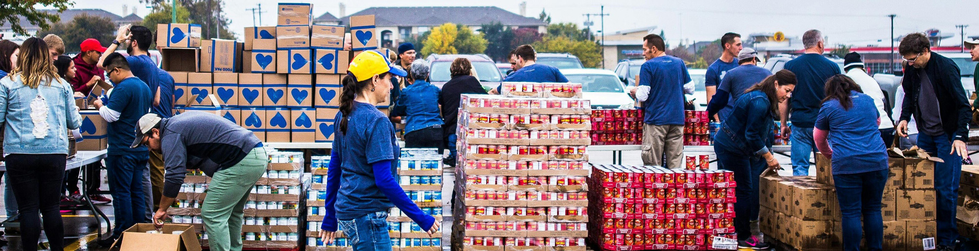 Food pantry volunteers handing out boxes of donated food.