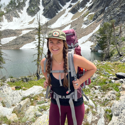 McKenna smiling at the camera while on a hike.