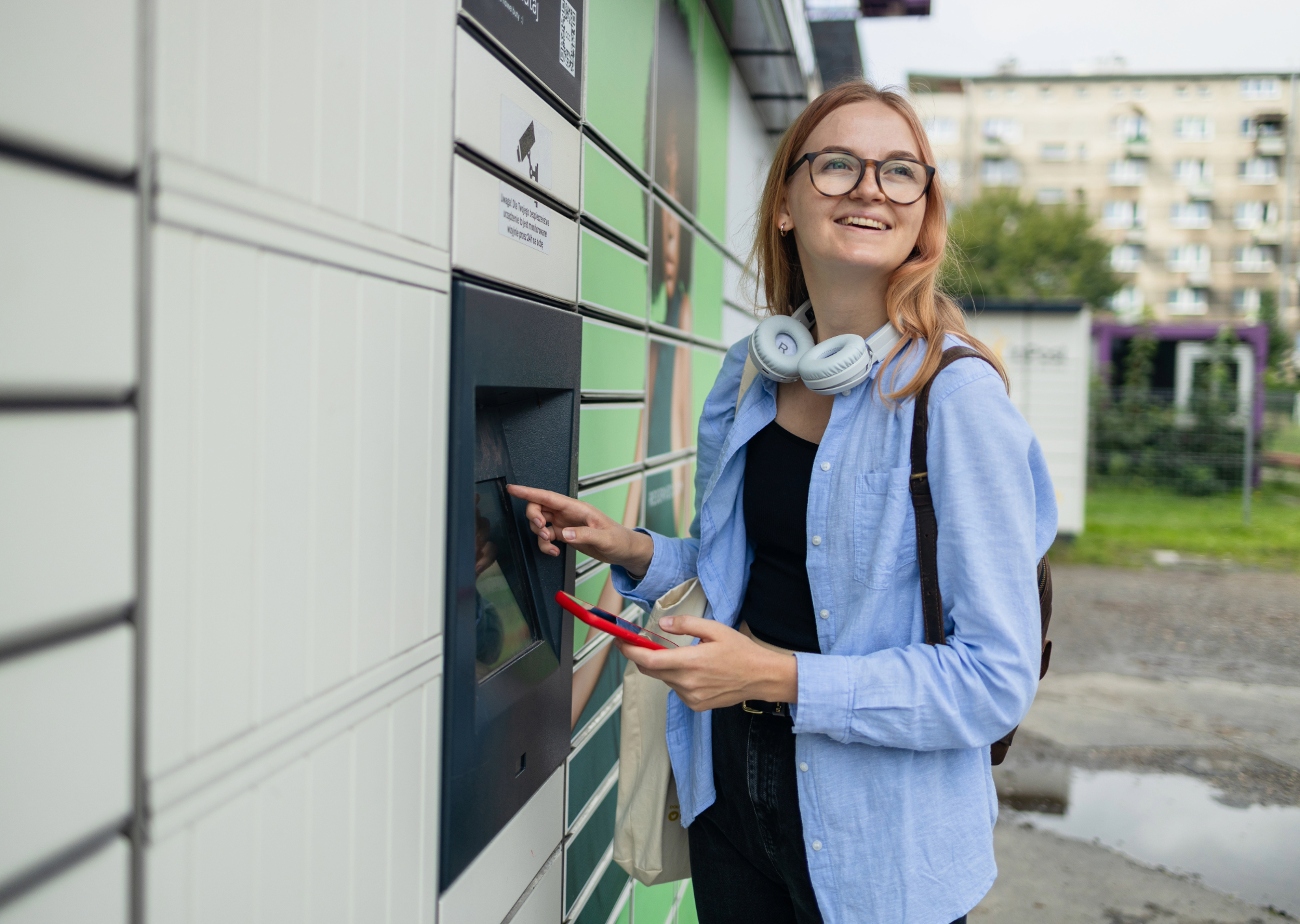 Female student standing outside in front of a row of smart lockers